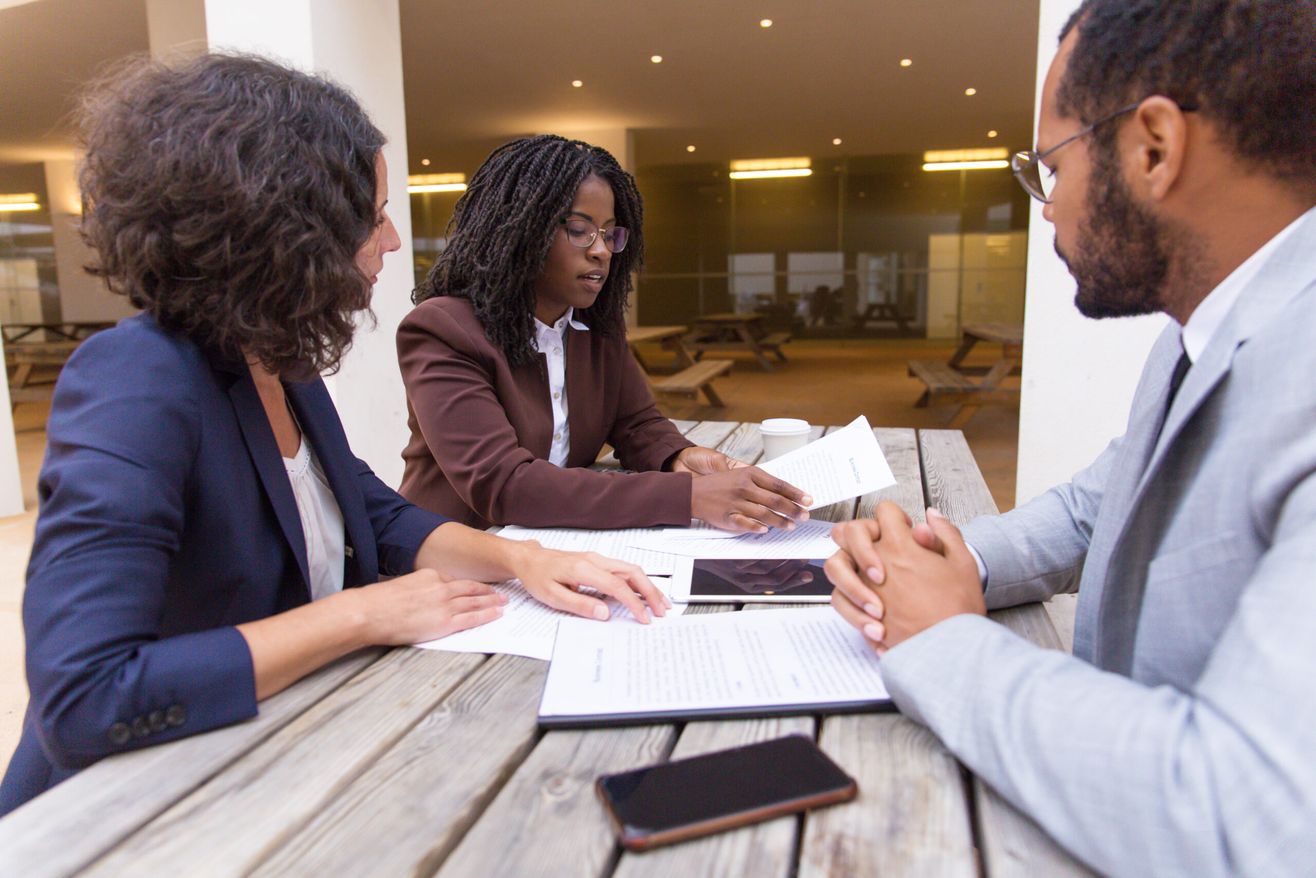 Business partners consulting legal expert in outdoor cafe